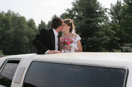 Bridegroom and bride are kissed in limousine